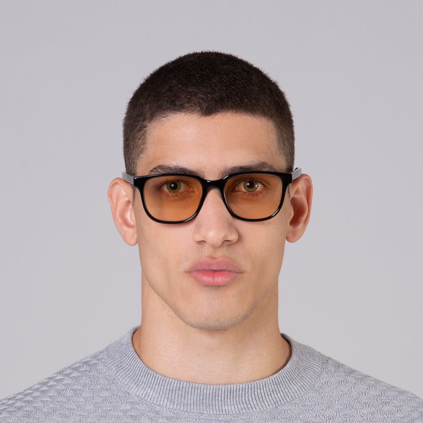 Óculos Carter Black com lente colorida laranja em modelo com rosto médio.