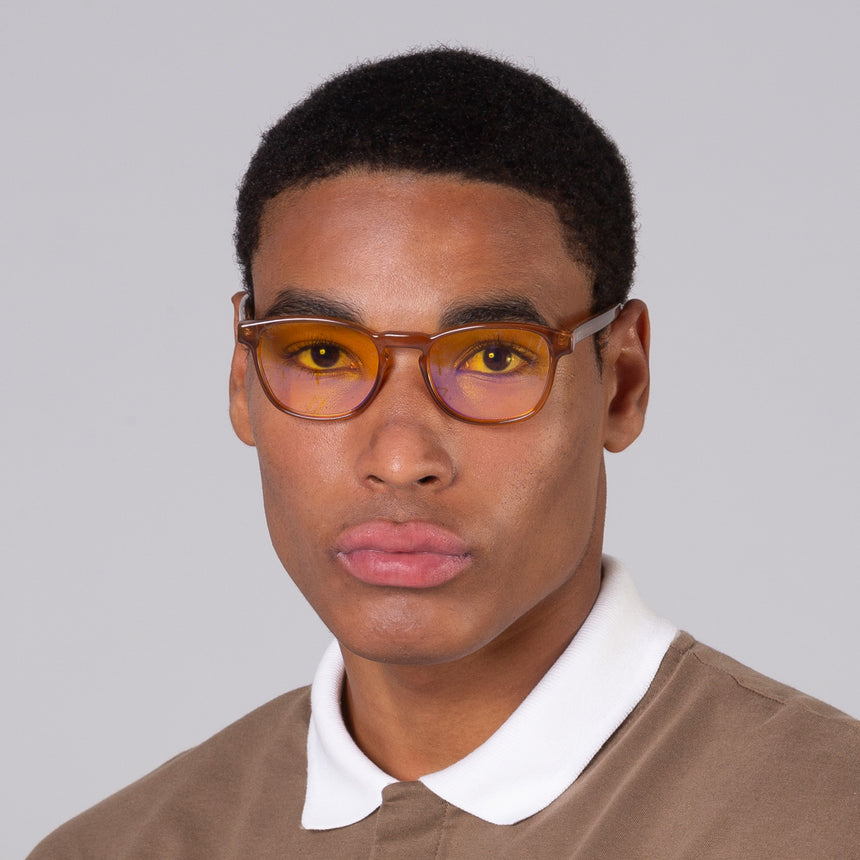 Modelo com rosto tamanho grande usa óculos Olli Camel com lente amarela