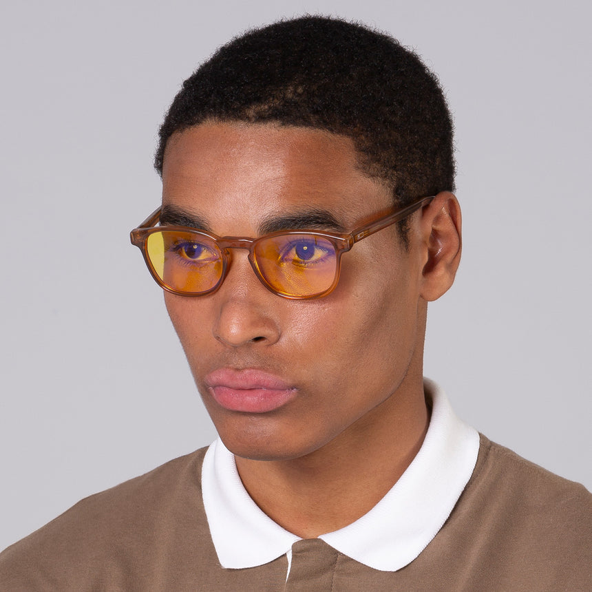 Modelo com rosto tamanho grande usa óculos Olli Camel com lente amarela