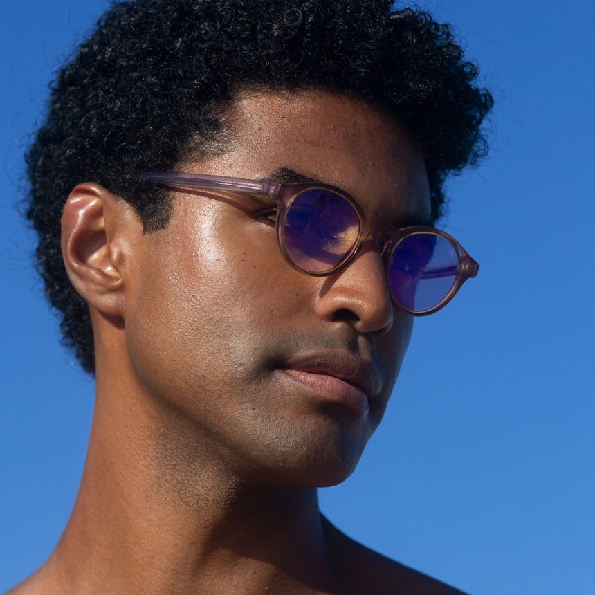 Modelo com rosto tamanho médio usa óculos Nino Rose com lente colorida lilás
