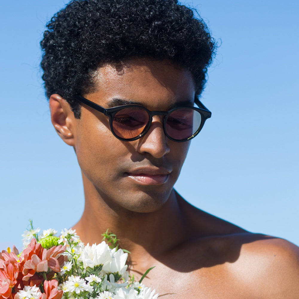 Óculos Taylor Black com lente colorida laranja em modelo com rosto médio.