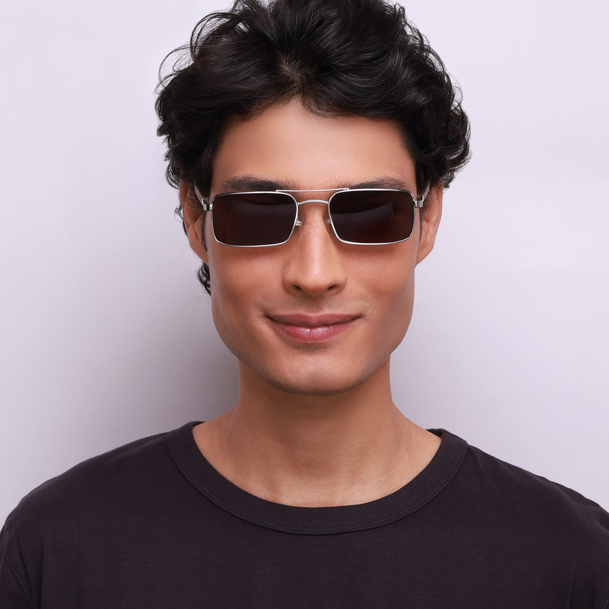 Óculos de metal retangular prata em modelo com rosto médio.