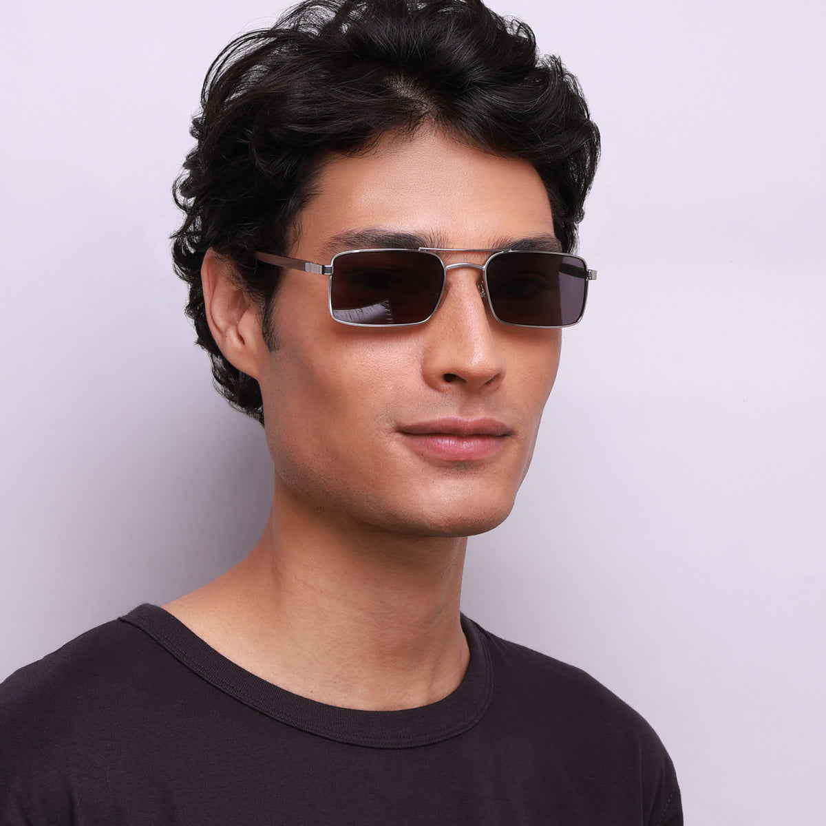 Óculos de metal retangular prata em modelo com rosto médio.