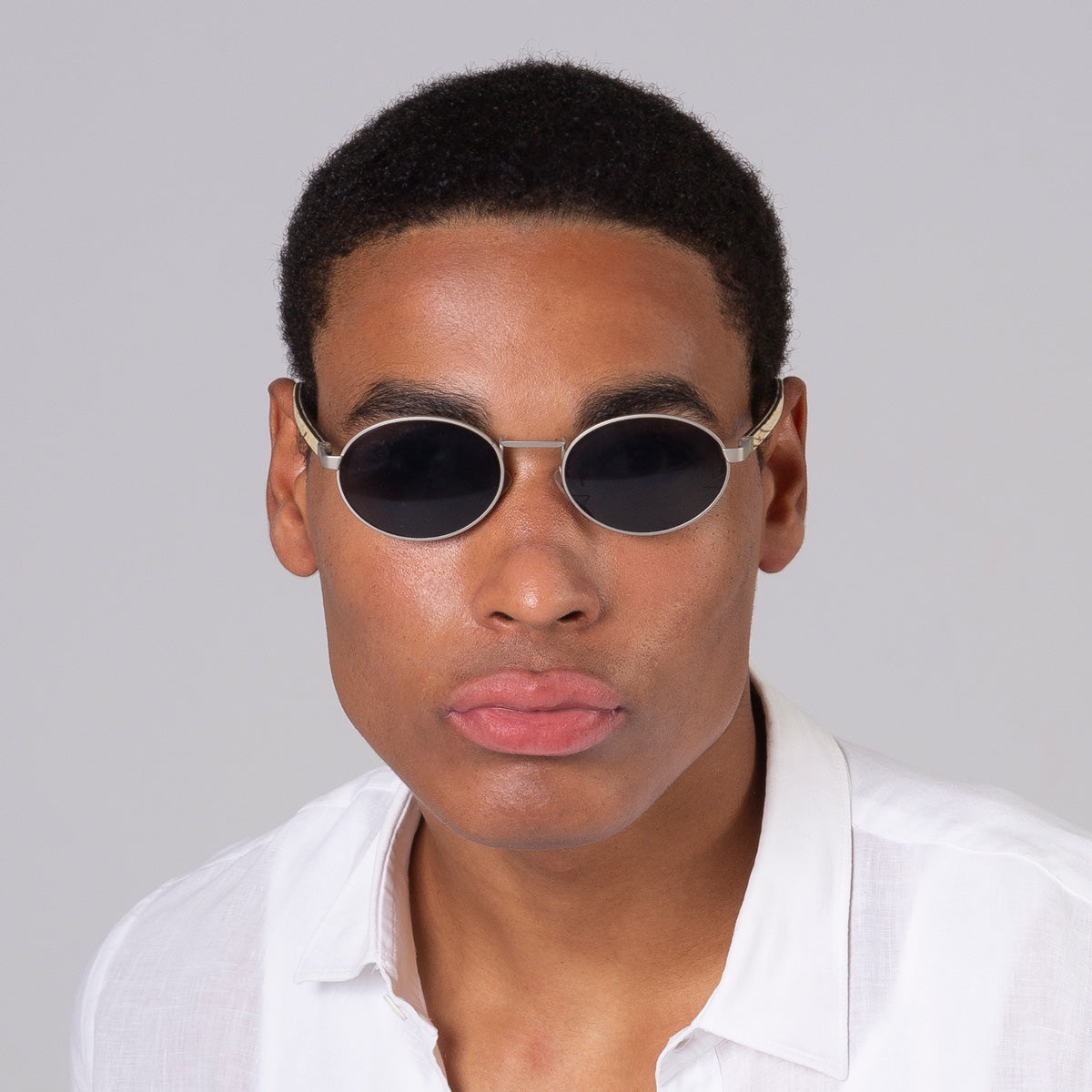 Óculos de metal oval prata em modelo com rosto grande.