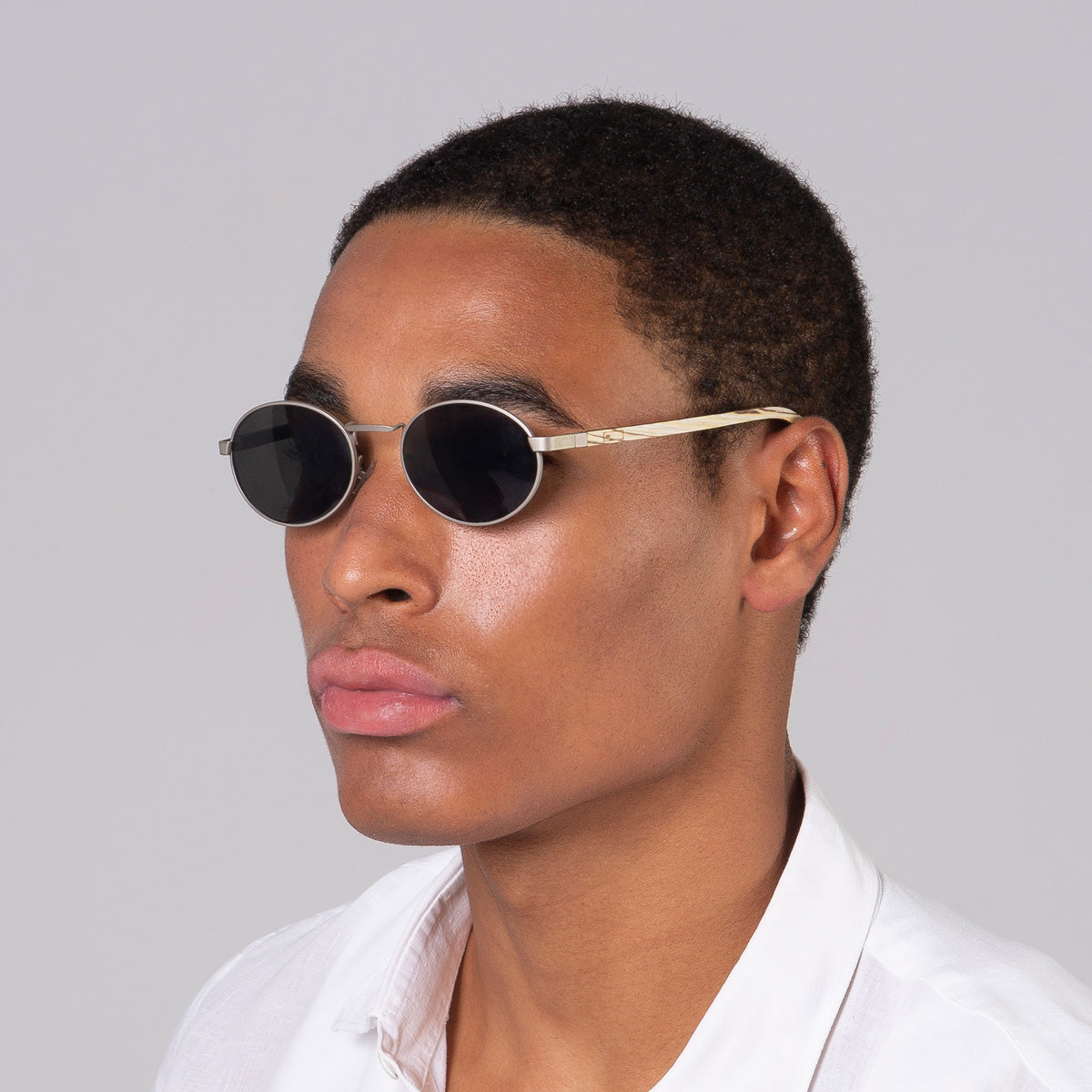 Óculos de metal oval prata em modelo com rosto grande.