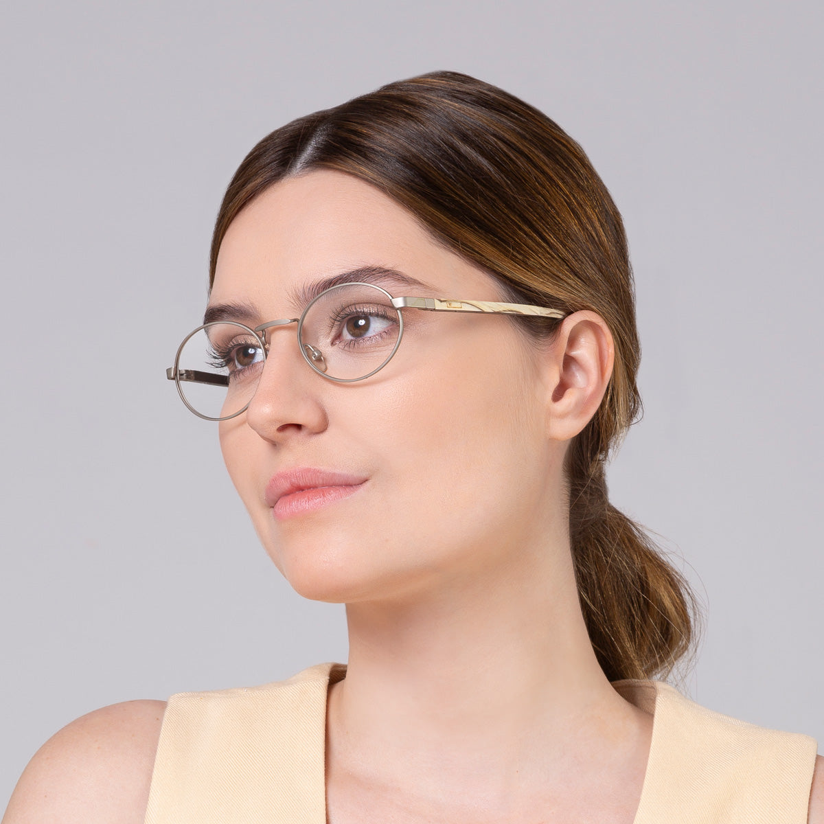 Armação de metal oval prata em modelo com rosto grande.