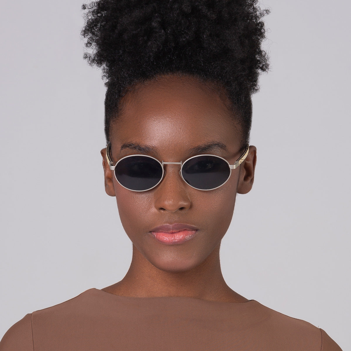 Óculos de metal oval prata em modelo com rosto pequeno.