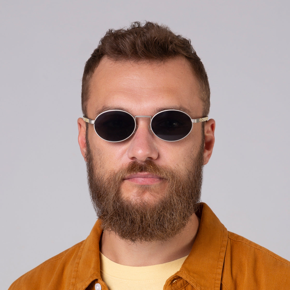 Óculos de metal oval prata em modelo com rosto grande.