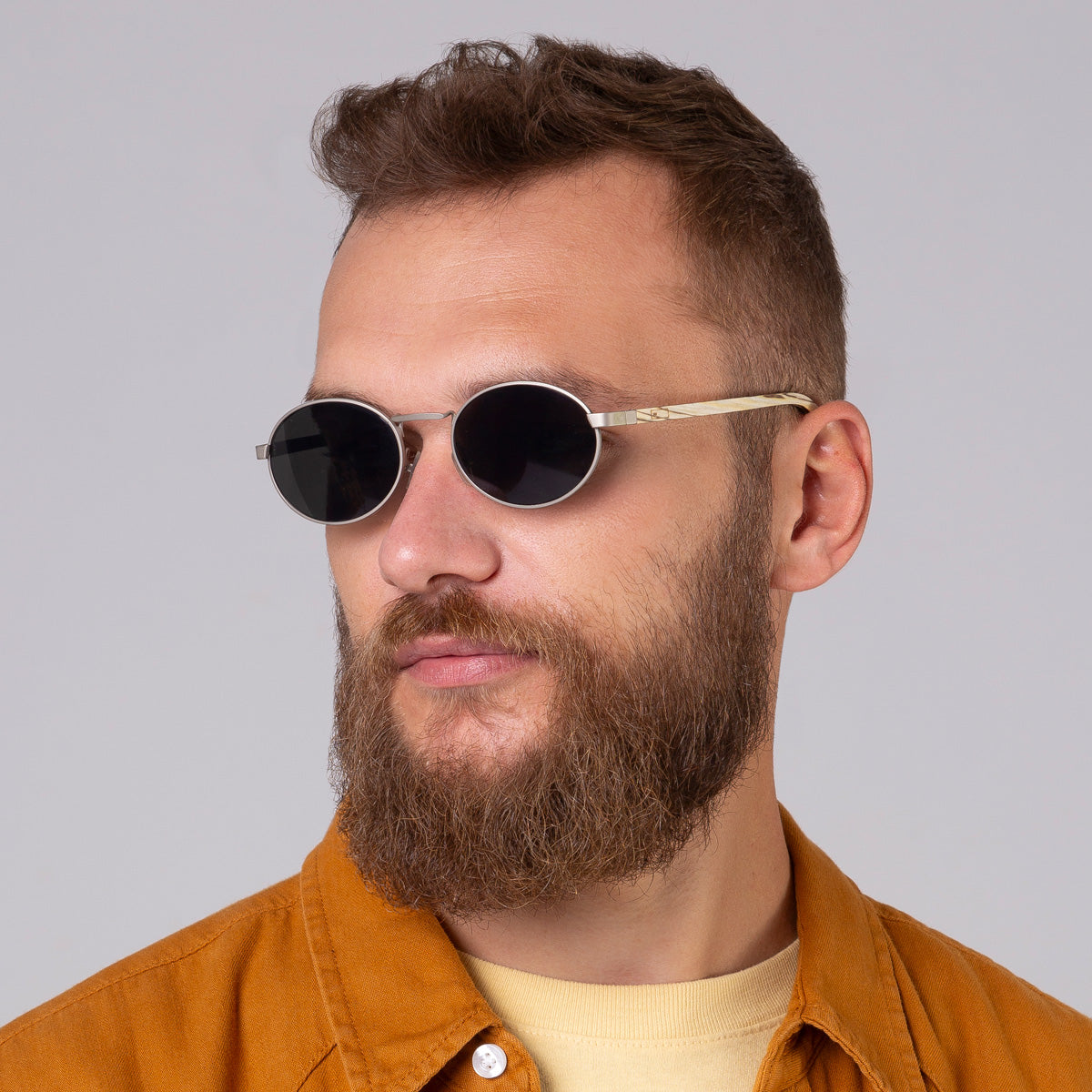 Óculos de metal oval prata em modelo com rosto grande.