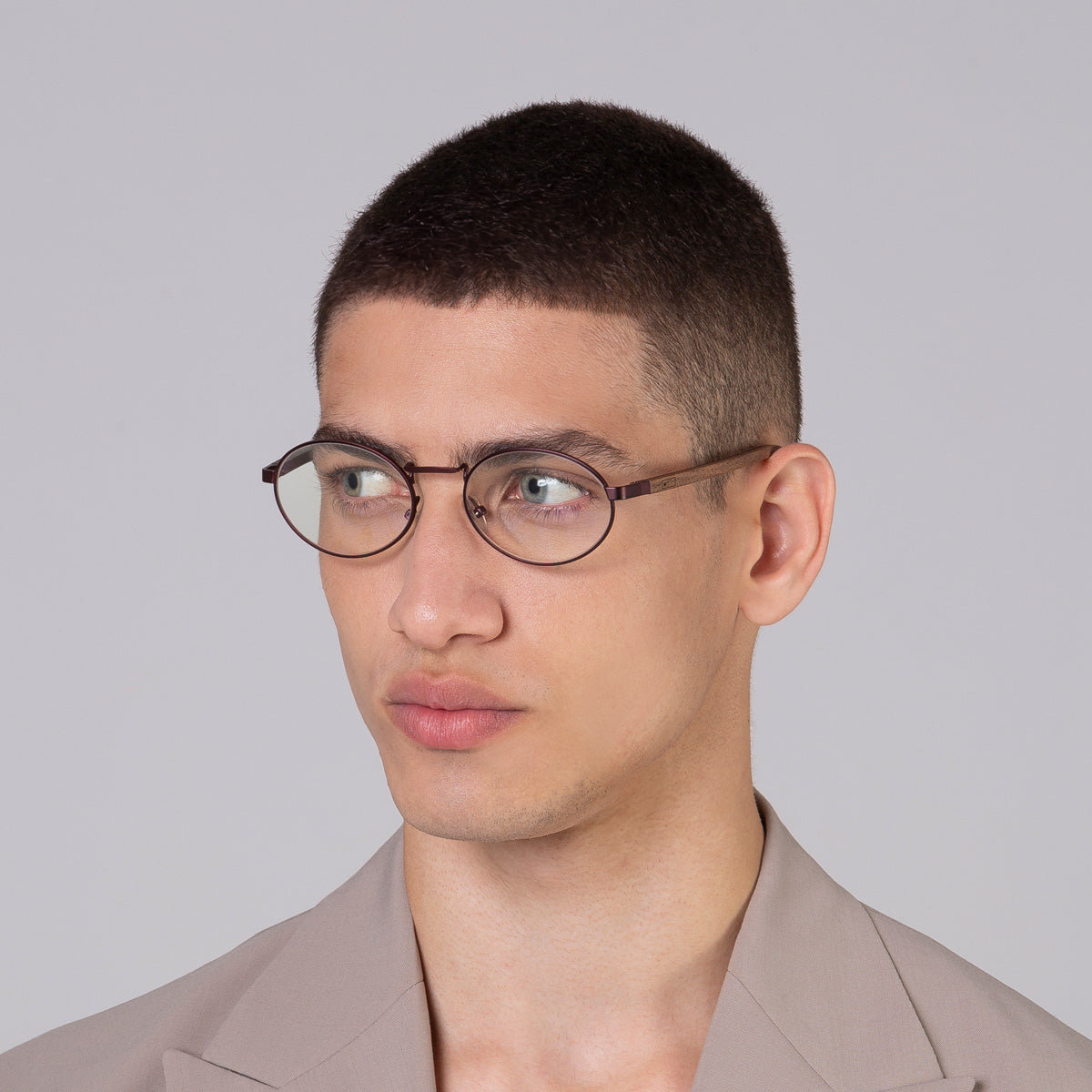 Armação de metal oval vinho em modelo com rosto médio.