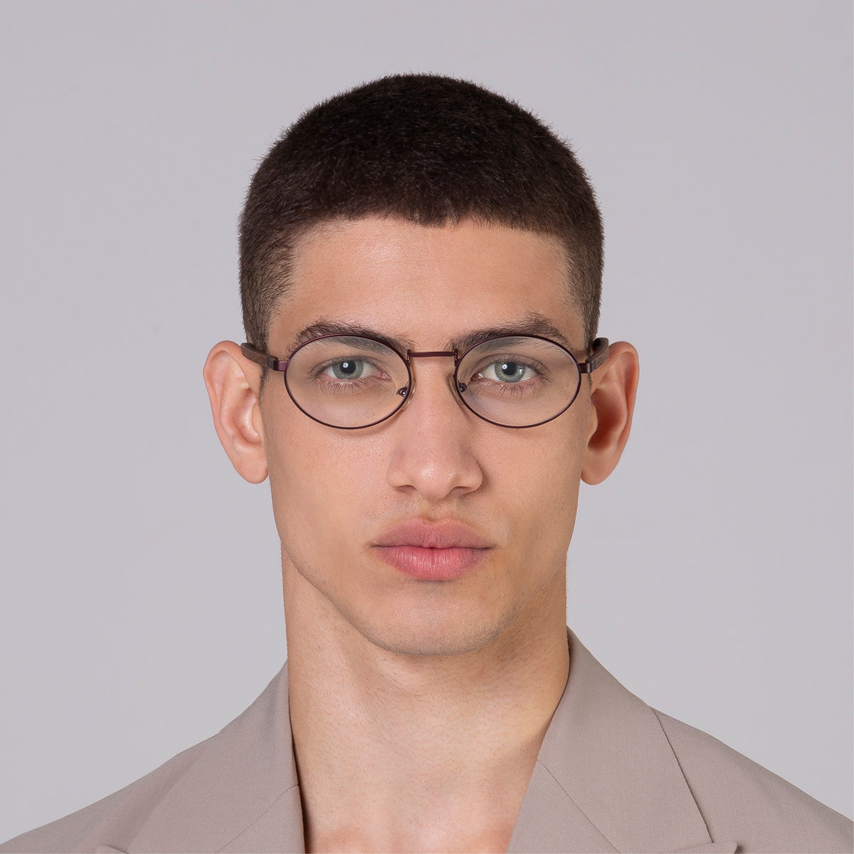 Armação de metal oval vinho em modelo com rosto médio.