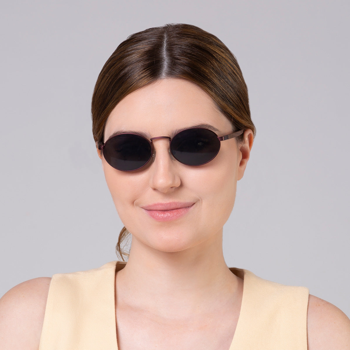 Óculos de metal oval vinho em modelo com rosto grande.