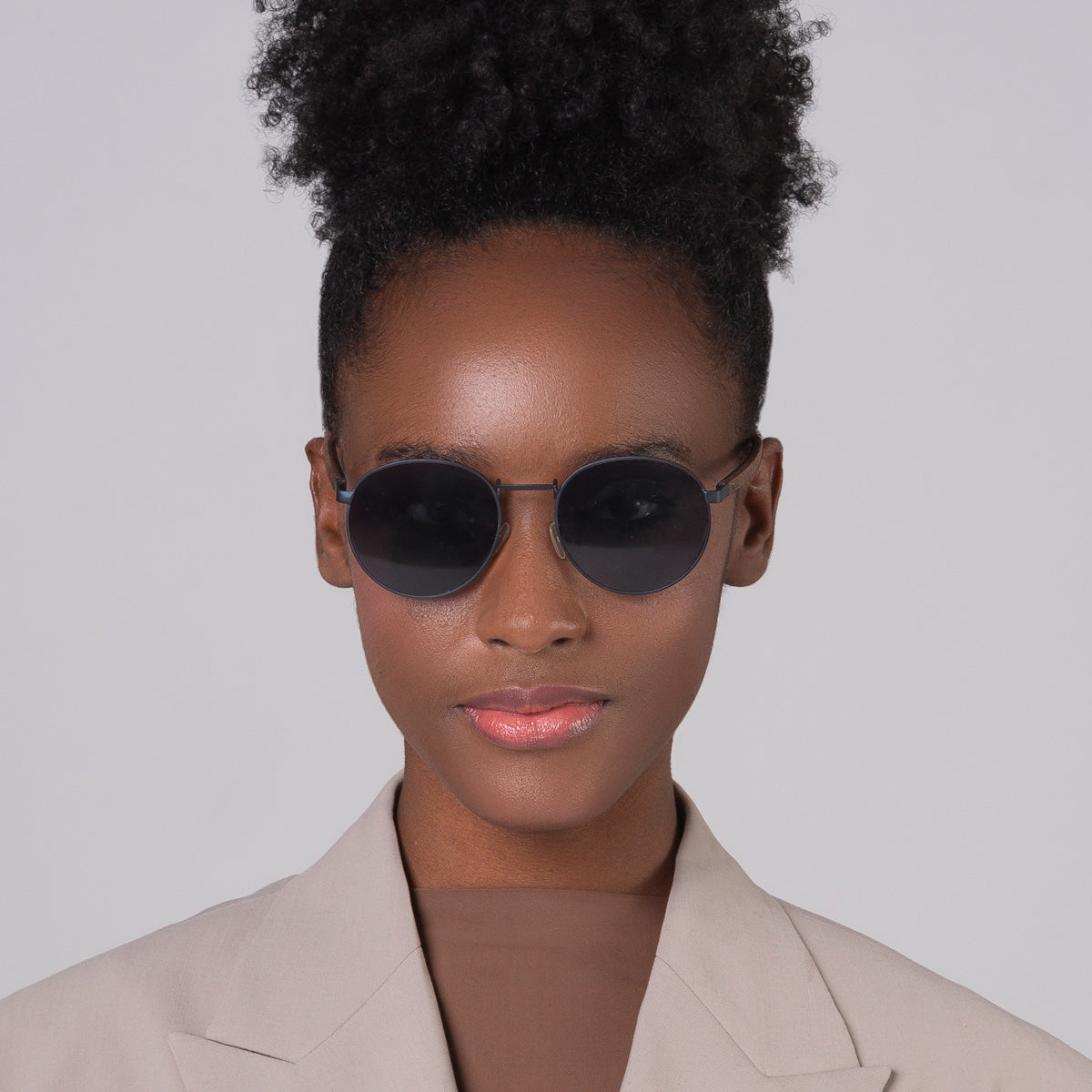 Óculos de metal redondo grande azul em modelo com rosto pequeno.