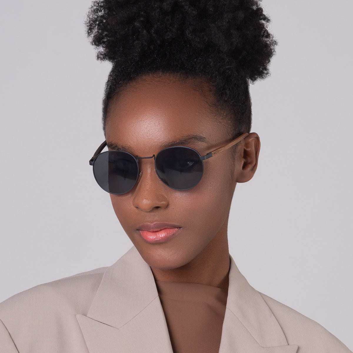 Óculos de metal redondo grande azul em modelo com rosto pequeno.