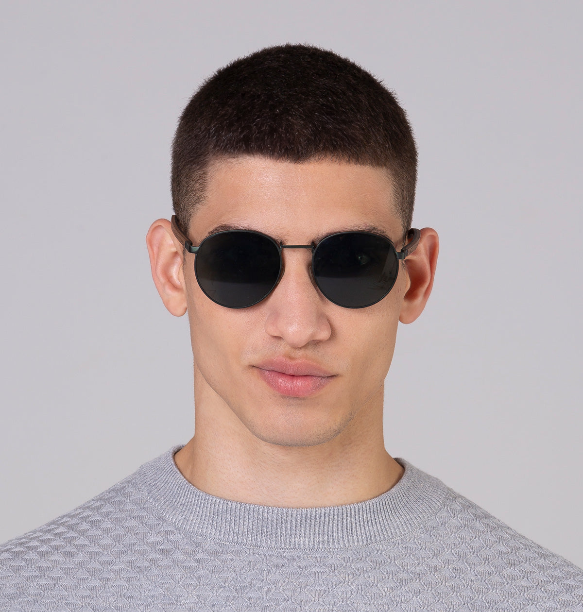 Óculos de metal redondo grande verde em modelo com rosto médio.