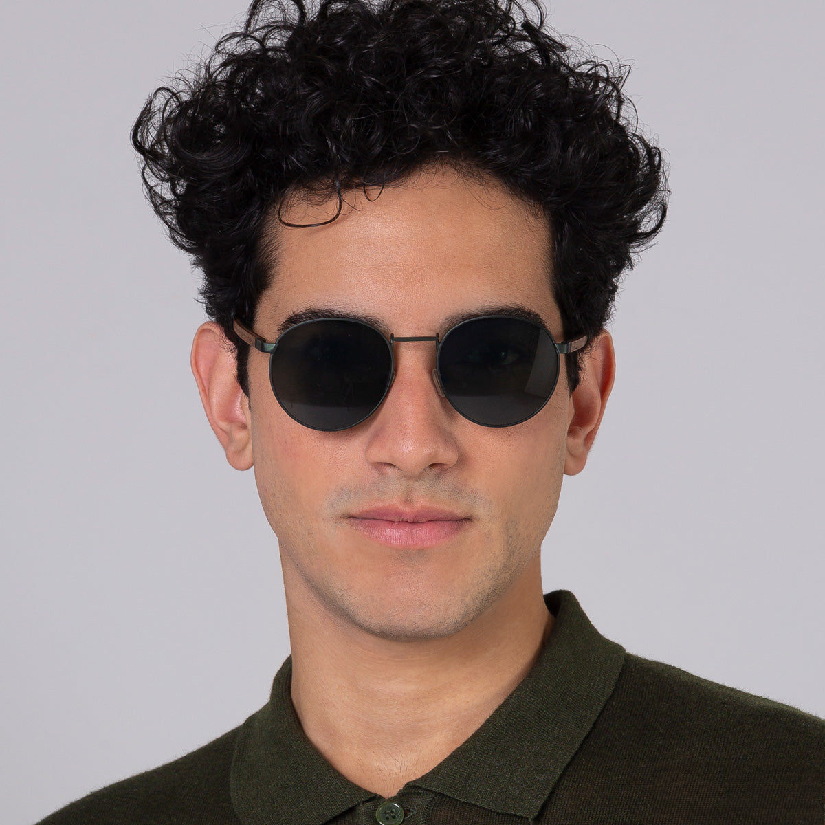 Óculos de metal redondo grande verde em modelo com rosto grande.