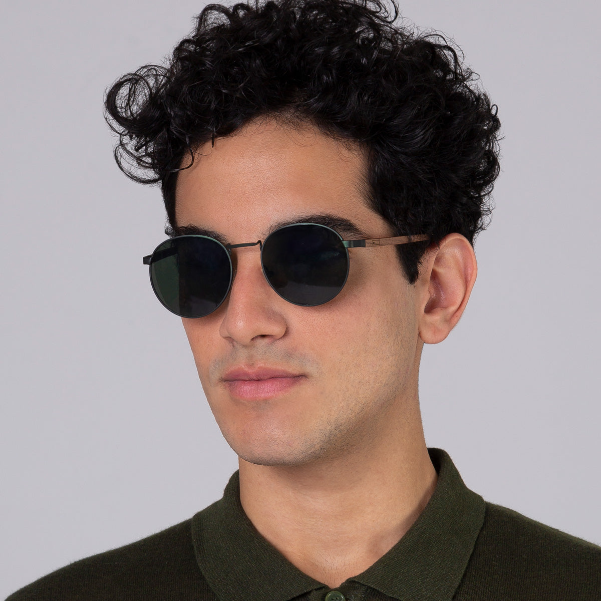 Óculos de metal redondo grande verde em modelo com rosto grande.