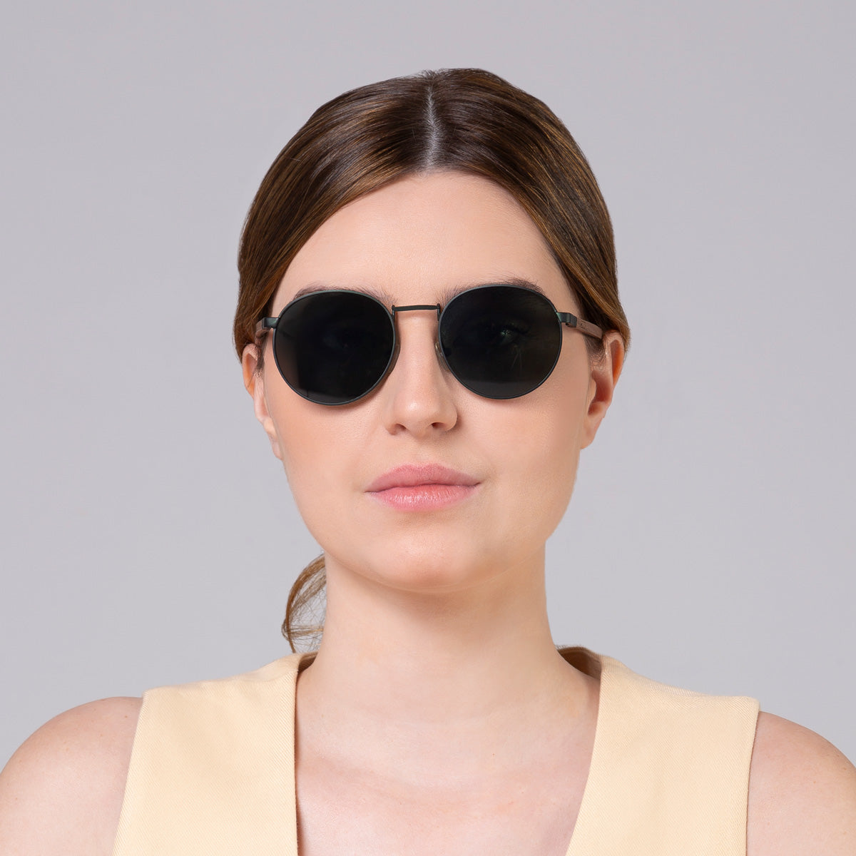 Óculos de metal redondo grande verde em modelo com rosto grande.