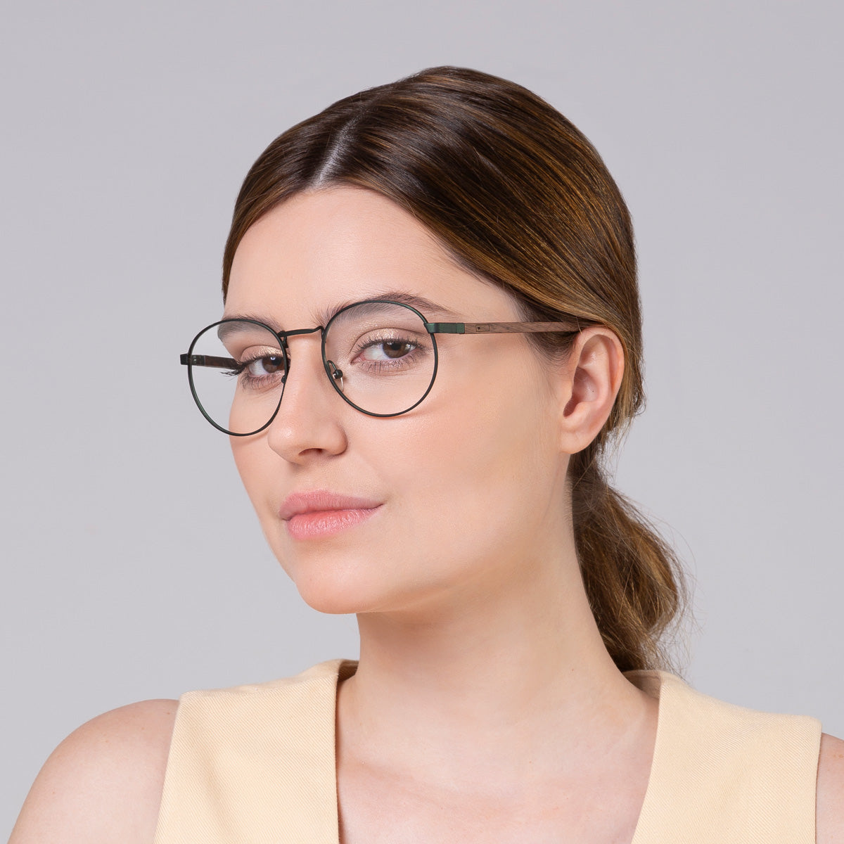 Armação de metal redondo grande verde em modelo com rosto grande.