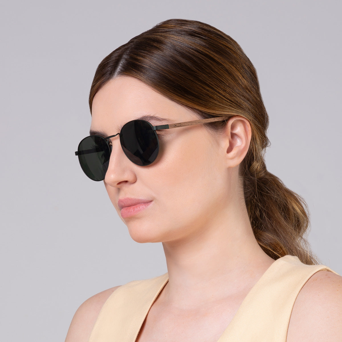 Óculos de metal redondo grande verde em modelo com rosto grande.