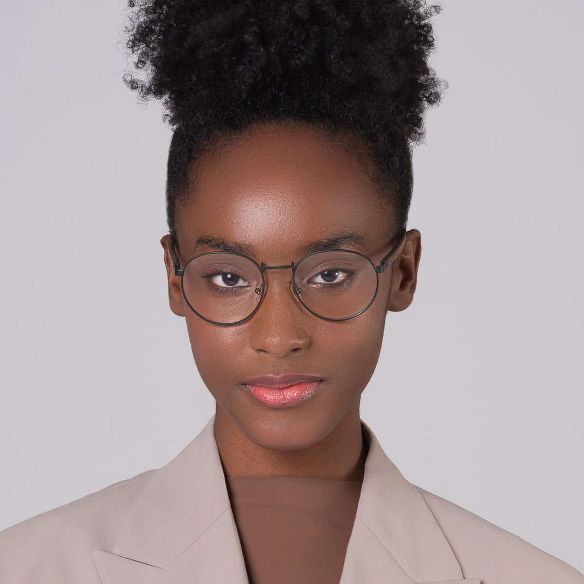 Armação de metal redondo grande verde em modelo com rosto pequeno.