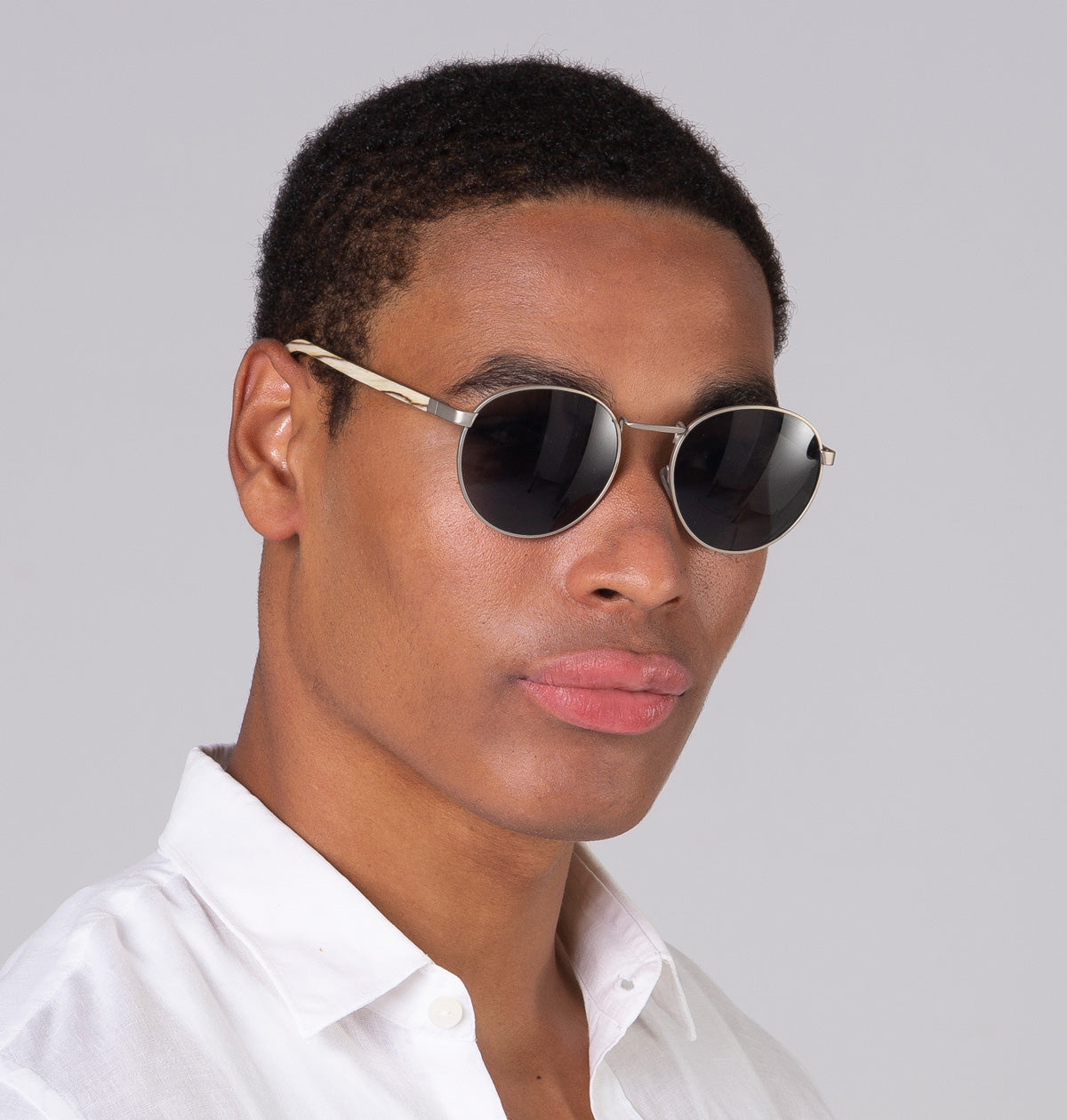 Óculos de metal redondo grande prata em modelo com rosto grande.