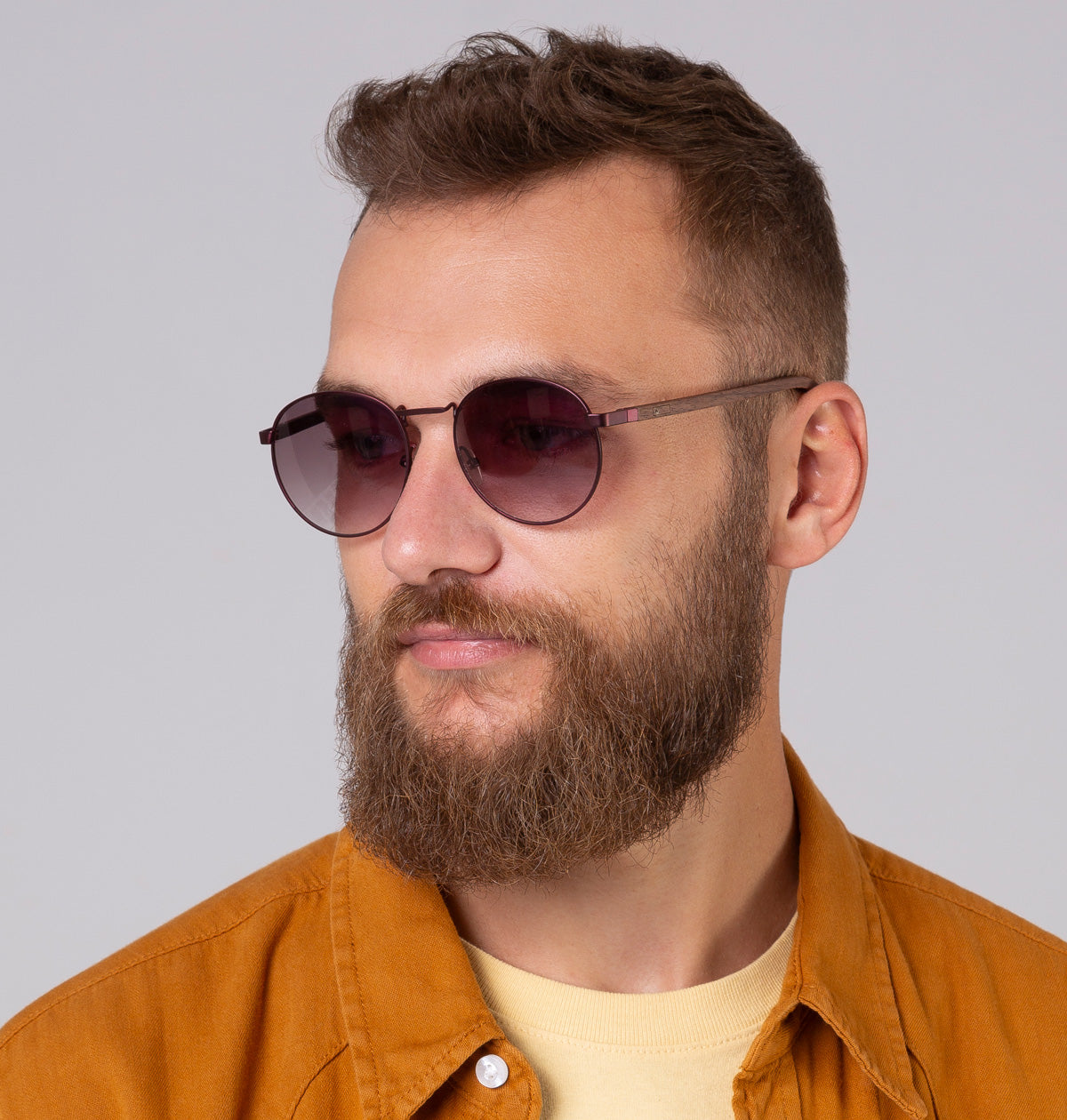 Óculos de metal redondo grande vinho em modelo com rosto grande.