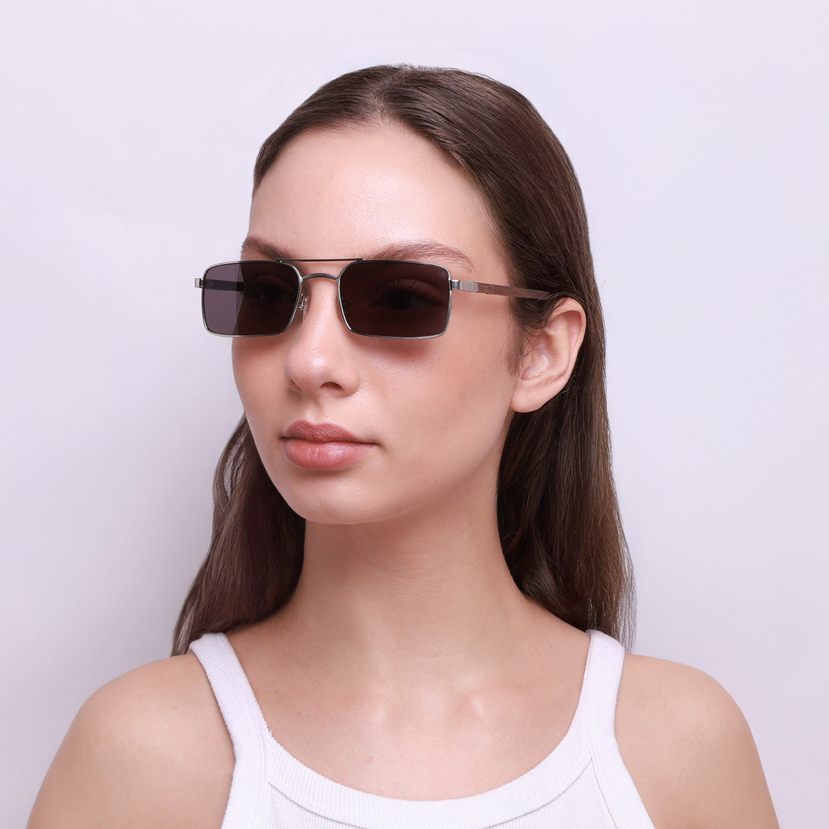 Óculos de metal retangular prata em modelo com rosto médio.