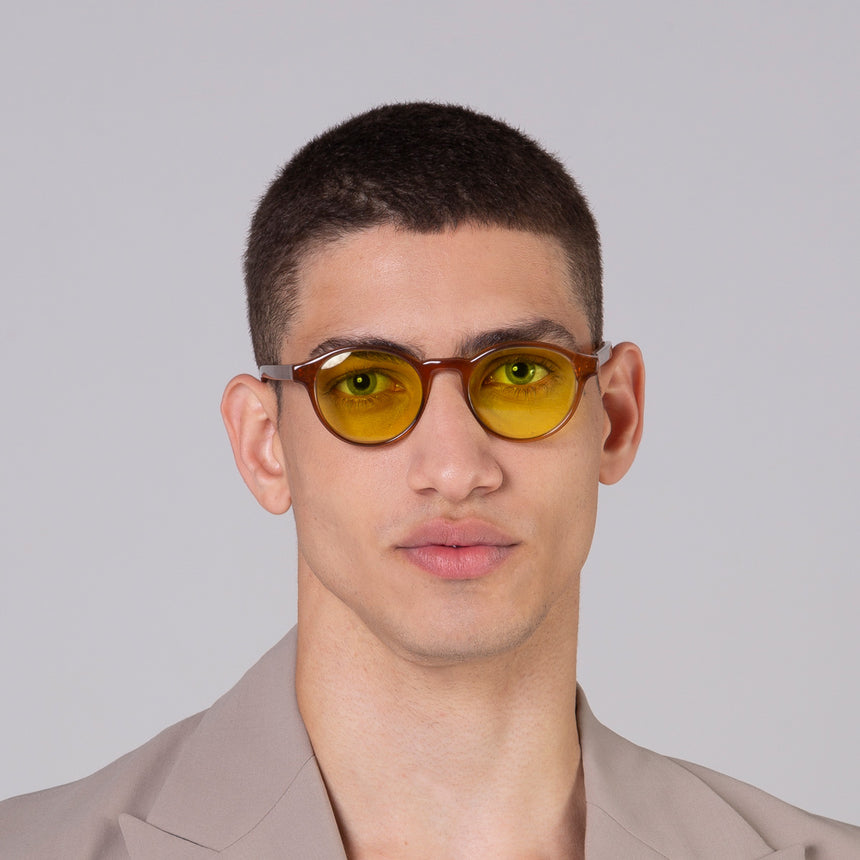 Modelo com rosto tamanho médio usa óculos Nino Camel com lente amarela