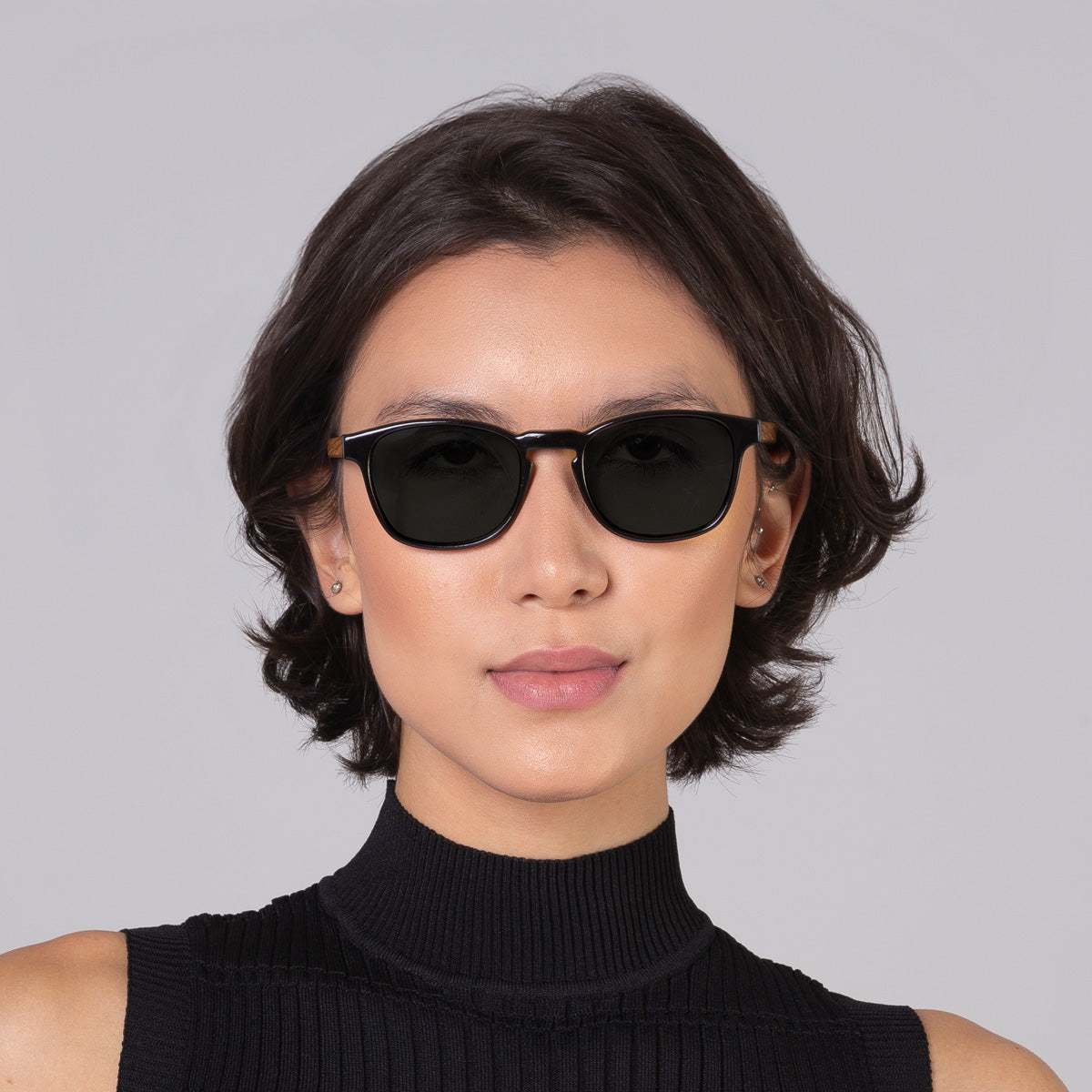 Modelo com rosto tamanho médio usa óculos Olli Black