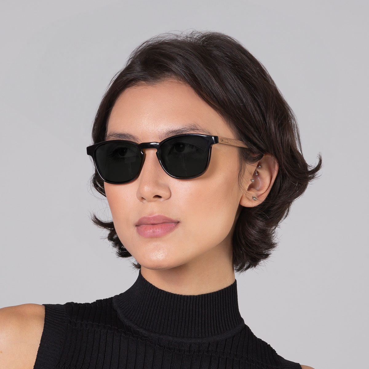 Modelo com rosto tamanho médio usa óculos Olli Black