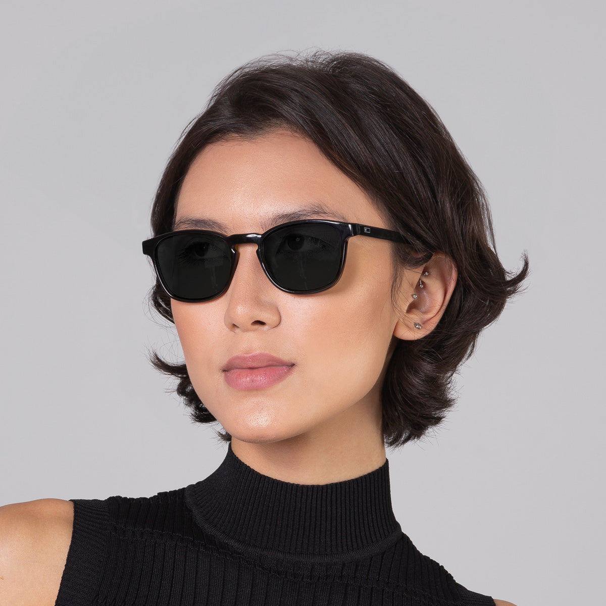 Modelo com rosto tamanho médio usa óculos Olli Black