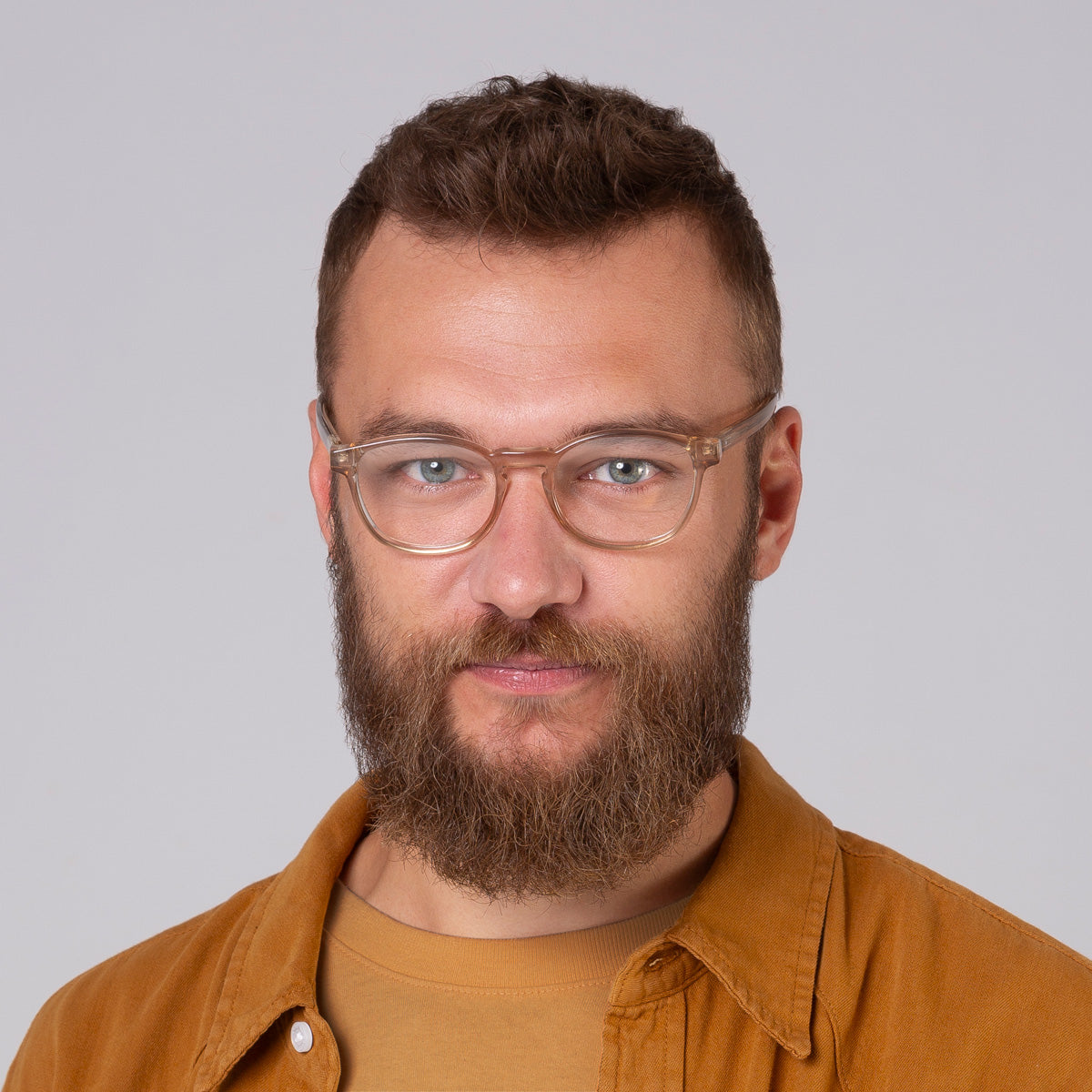 Modelo com rosto tamanho grande usa armação Olli Champanhe