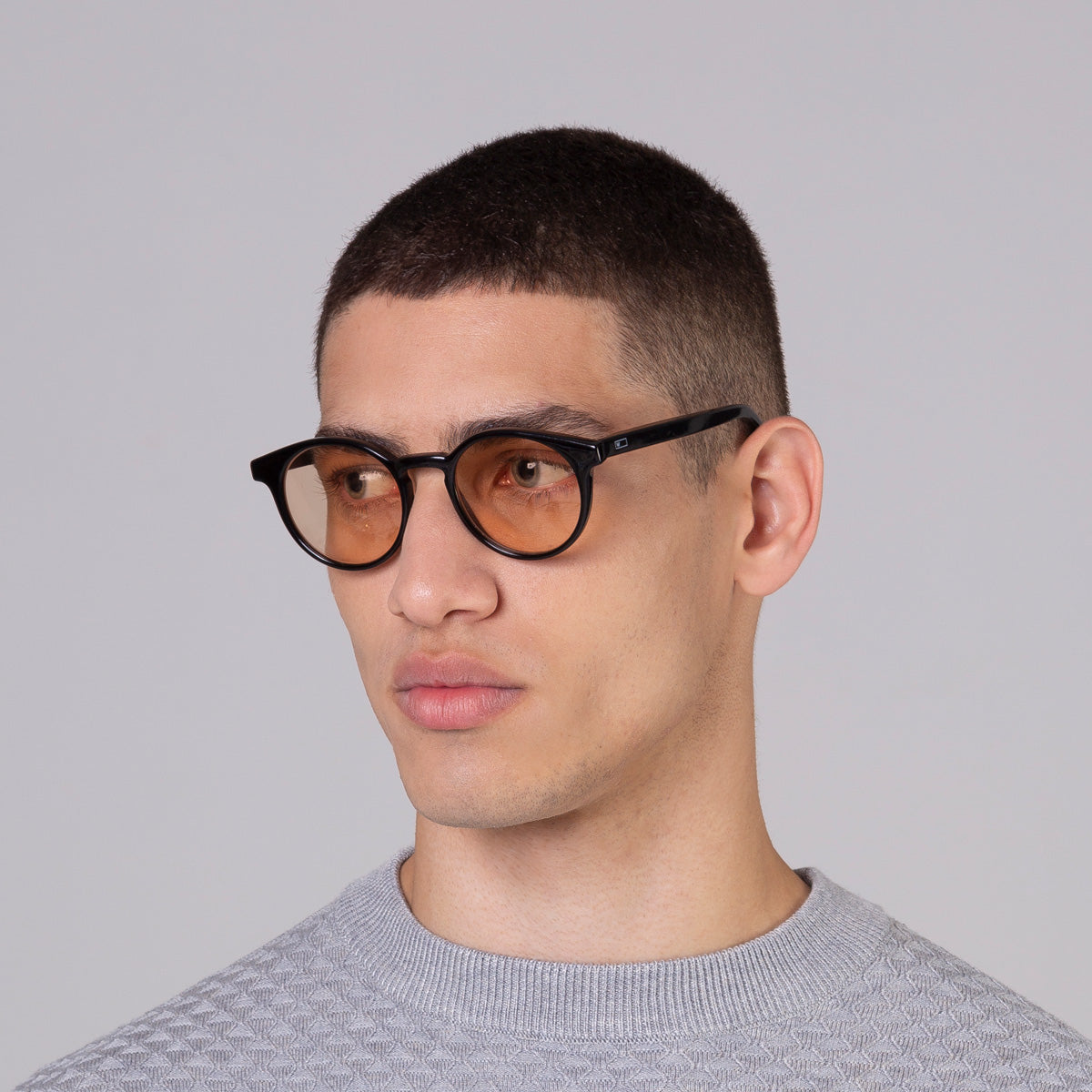 Óculos Taylor Black com lente colorida laranja em modelo com rosto médio.