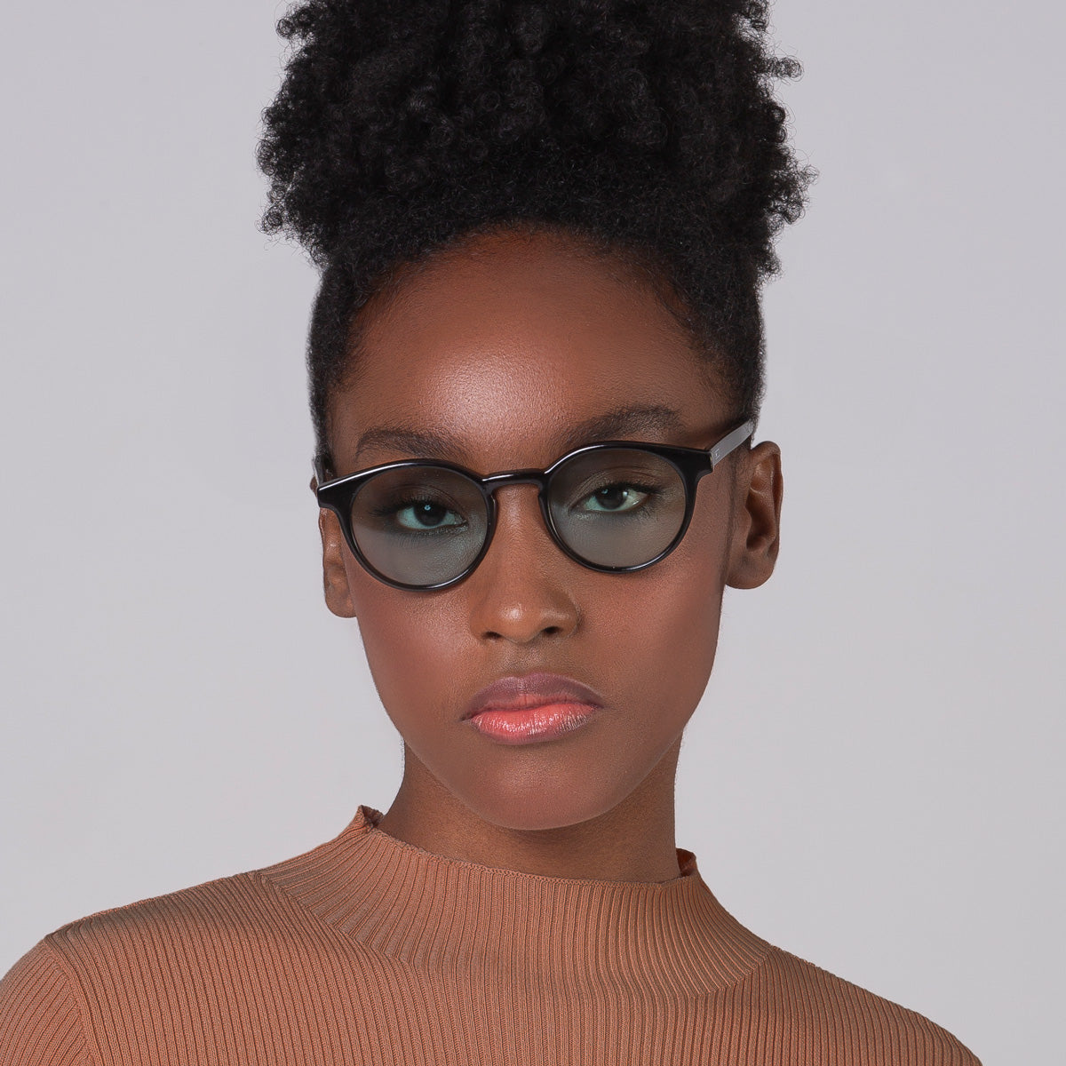 Óculos Taylor Black com lente colorida verde clara em modelo com rosto pequeno.